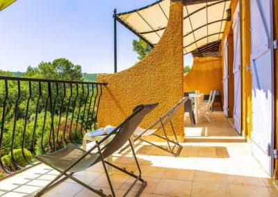 Terrasse ensoleillée avec deux transats, offrant une vue panoramique imprenable