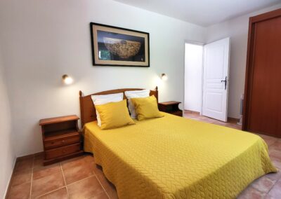 Chambre avec lit double aux draps jaunes