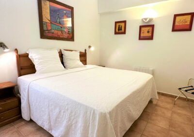 Chambre avec lit en bois aux draps blancs