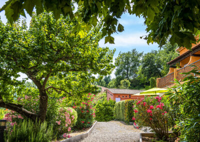 Jardins verdoyants et fleuris des Terrasses de Figanières sous un soleil radieux, offrant un cadre idéal pour se détendre.