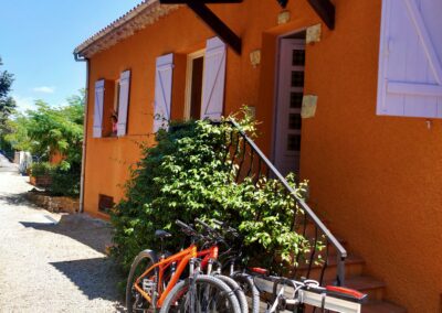 Entrée des appartements avec deux vélos stationnés à côté des escaliers de la résidence